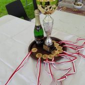 Na zdjęciupuchar, szampan oraz medale